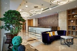 a lobby with a blue couch and a table at K Hotel Taipei Chang-An in Taipei