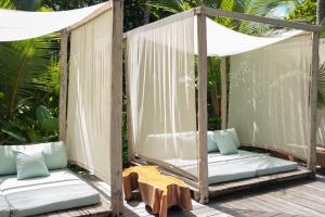 a porch swing with pillows and a table at The Resort at Isla Palenque Member of the Cayuga Collection in Boca Chica