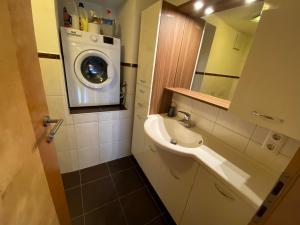 een badkamer met een wasmachine en een wastafel bij Haus Gaberhel in Ellmau +35 foto's