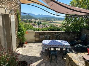 einen Tisch und Stühle auf einer Terrasse mit Aussicht in der Unterkunft La Villa du bonheur in Puy-Saint-Martin