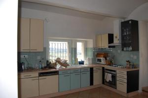 eine Küche mit weißen Schränken und blauen Geräten in der Unterkunft La Villa du bonheur in Puy-Saint-Martin