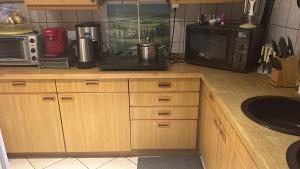 a kitchen with a counter top with a microwave and a stove at Souterrainwohnung Zum Leiselsee in Baunatal