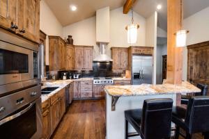 une cuisine avec des placards en bois et un grand îlot dans l'établissement The Shores Riverside Townhome: Peaceful Luxury, à Gold Hill