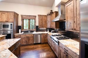 une grande cuisine avec des placards en bois et des appareils en acier inoxydable dans l'établissement The Shores Riverside Townhome: Peaceful Luxury, à Gold Hill 25 autres photos