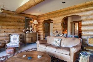 un salon avec un canapé et une table dans l'établissement Swan River Lodge Home: Spacious, Hot Tub, à Gold Hill