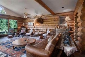 un salon avec un canapé et une table dans l'établissement Swan River Lodge Home: Spacious, Hot Tub, à Gold Hill