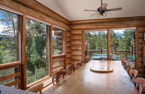 - une salle à manger avec une table, des chaises et de grandes fenêtres dans l'établissement Swan River Lodge Home: Spacious, Hot Tub, à Gold Hill
