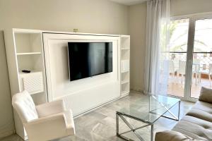 ミハス・コスタにあるMI CAPRICHO 2D BEACHFRONT- Apartment with sea view - Costa del Solのリビングルーム(テレビ、ソファ、ガラステーブル付)