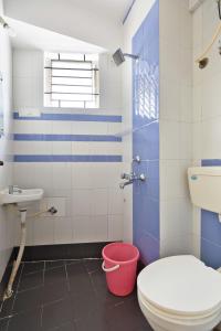 een badkamer met een toilet, een wastafel en een emmer bij Stayhome Classic in Bangalore