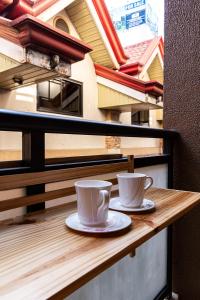 2 tazas de café sentadas en una mesa en un balcón en Johannes Condo in Baguio Megatower IV, en Baguio