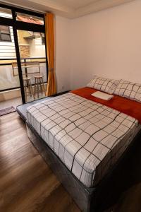 1 Schlafzimmer mit 2 Betten und einem Balkon in der Unterkunft Johannes Condo in Baguio Megatower IV in Baguio City