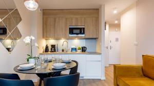 a kitchen and dining room with a table and chairs at VacationClub - Apartamenty Zakopiańskie Apartament 427 in Zakopane