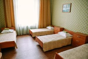 a hotel room with three beds and a window at Krimuldas Muiža in Sigulda