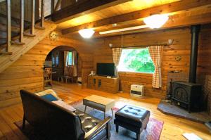 那須的住宿－HARUNA LODGE Private log house with starry sky from the skylight, fireplace, and spacious deck BBQ，小木屋内的客厅设有壁炉