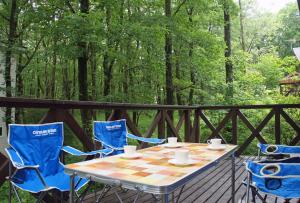 那須的住宿－HARUNA LODGE Private log house with starry sky from the skylight, fireplace, and spacious deck BBQ，甲板上的桌椅,配有棋盘