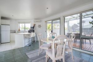 a kitchen and dining room with a table and chairs at Relaxed Poolside Living in a Resort-style Setting in Safety Beach