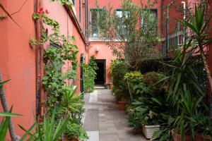 ローマにあるAventino apartmentの植物とピンクの建物のある路地