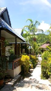 un portico di una casa con panchina e palme di Lovely Lanta Resort a Ko Lanta