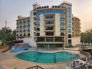 a hotel with a swimming pool in front of a building at Paragon Hotel and Resort in Sreemangal