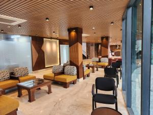 eine Lobby mit Sofas, Tischen und Stühlen in der Unterkunft Paragon Hotel and Resort in Sreemangal