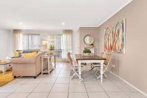 a living room with a table and a couch at Shore Haven - A Relaxed Seaside Stay in Port Noarlunga