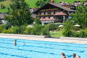 a group of people swimming in a swimming pool at Martinerhof's Brauhotel in San Martino