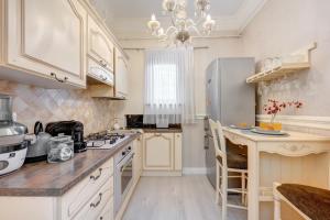 a kitchen with white cabinets and a refrigerator at Beautiful 2BedFlatCismigiu in Bucharest