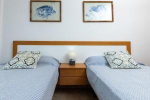 deux lits côte à côte dans une chambre dans l'établissement Casa Dana El Cotillo with private terrace, à El Cotillo