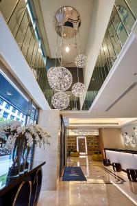 a lobby with chairs and chandeliers in a building at K Hotel Tianjin in Taipei
