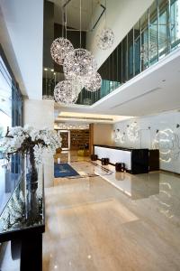 a lobby with chandeliers and flowers in a building at K Hotel Tianjin in Taipei