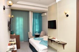 Cette chambre comprend un lit et une télévision. dans l'établissement Karat Inn Boutique Hotel, à Baku