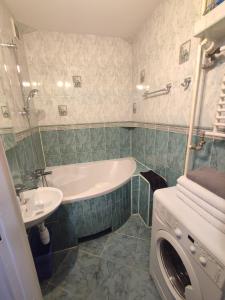 een badkamer met een bad, een wastafel en een wasmachine bij Mieszkanie ul. Raciborskiego in Mielec