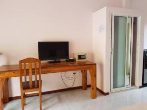 a wooden desk with a television and a chair at เขาหลัก ซัมเมอร์เฮาส์ 2 in Khao Lak