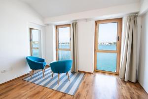 a room with two blue chairs and a view of the water at Umag apartment center seafront seaview old town 2 by Rentistra in Umag