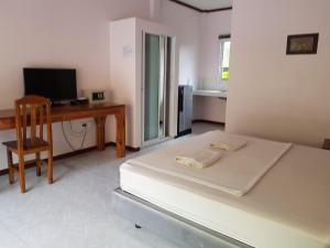 a bedroom with a bed and a desk and a chair at เขาหลัก ซัมเมอร์เฮาส์ 2 in Khao Lak
