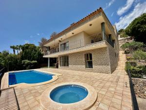 uma casa com uma piscina em frente em Villa la Parreta Ref025 em Las Villas