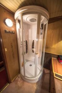 a white shower in a room with a door at Classic riverboat in the center of Paris in Paris