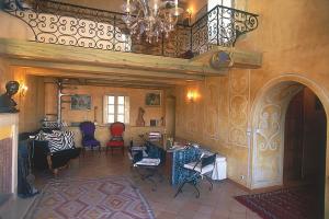 Una sala de estar con sillas y una lámpara de araña. en Le Maria Venezia, en LʼÎle-Rousse