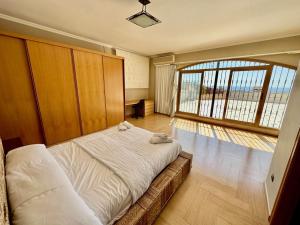 um quarto com uma cama e uma grande janela em Villa la Parreta Ref025 em Las Villas