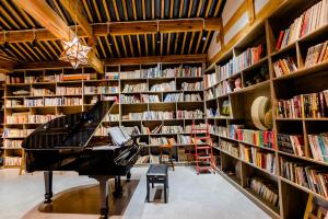a library with a piano in the middle at Lijiang One House Designer Guesthouse in Lijiang