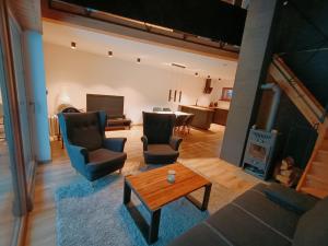 a living room with a couch and chairs and a table at Czarna Chata in Jaworzynka
