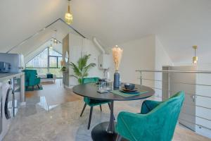 een keuken en eetkamer met een tafel en groene stoelen bij Welcome to the Verde in Alfortville