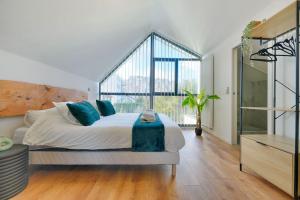 een slaapkamer met een bed en een groot raam bij Welcome to the Verde in Alfortville