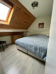 ein Schlafzimmer mit einem Bett im Dachgeschoss in der Unterkunft vakantiewoning Heidehoek in Middelkerke