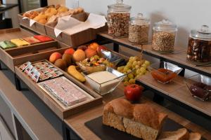 un buffet con diferentes tipos de pan y otros alimentos en Panorama Hotel Friuli - Boutique Hotel, en San Daniele del Friuli