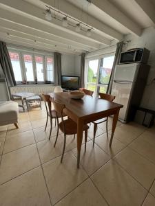 eine Küche und ein Esszimmer mit einem Holztisch und Stühlen in der Unterkunft vakantiewoning Heidehoek in Middelkerke
