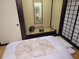 a bedroom with a bed with a round bedspread at Iroriyado Hidaya in Takayama