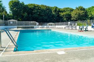 a swimming pool with blue water in a yard at Camping Pods Trevella Holiday Park in Crantock