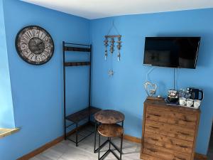 a room with a blue wall with a clock and a stool at ISLAND LODGE on the Hoe, Barbican, Free Parking in Plymouth