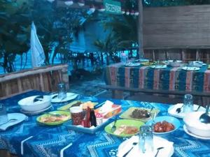 a table with plates of food on a blue table cloth at Beser Bay Homestay in Besir